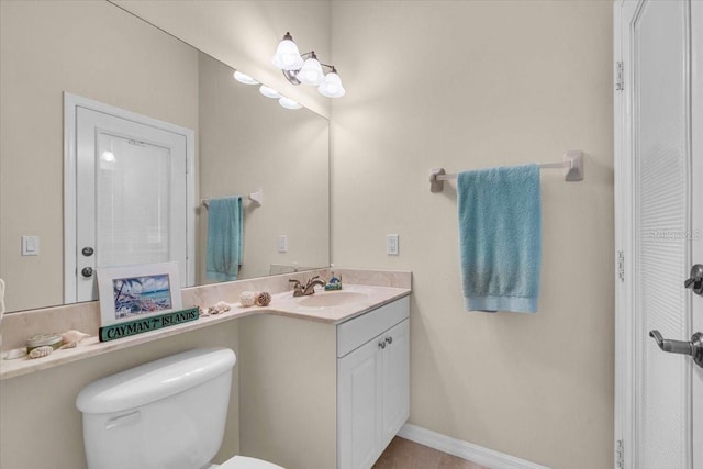 bathroom featuring vanity, toilet, and baseboards