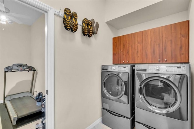 clothes washing area with ceiling fan, baseboards, cabinet space, and washer and dryer