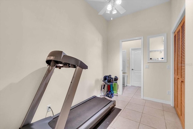 workout room featuring light tile patterned floors, ceiling fan, and baseboards