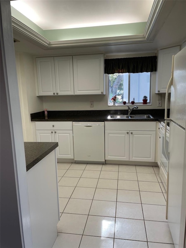 kitchen featuring sink, white appliances, light tile patterned floors, white cabinetry, and a tray ceiling