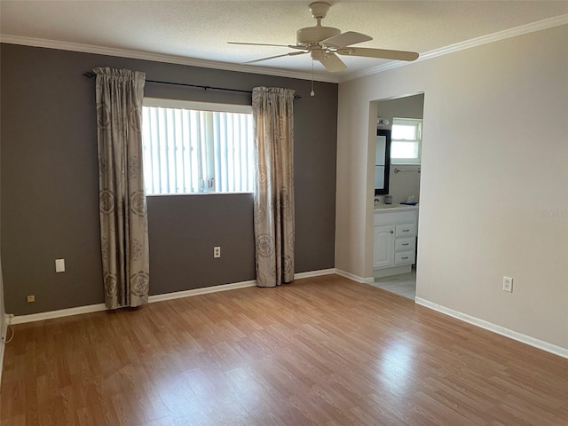 empty room featuring ceiling fan, ornamental molding, light hardwood / wood-style floors, and a textured ceiling