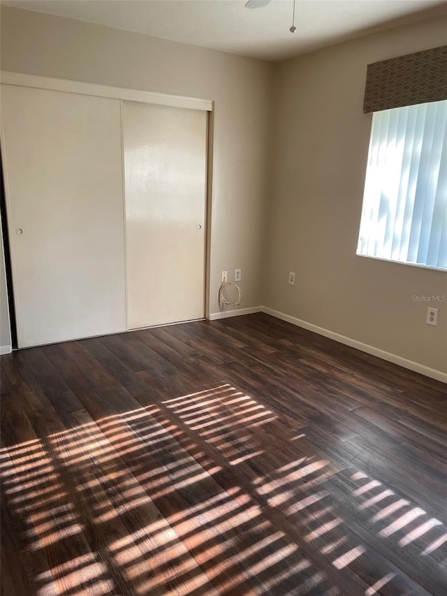 empty room with dark hardwood / wood-style flooring