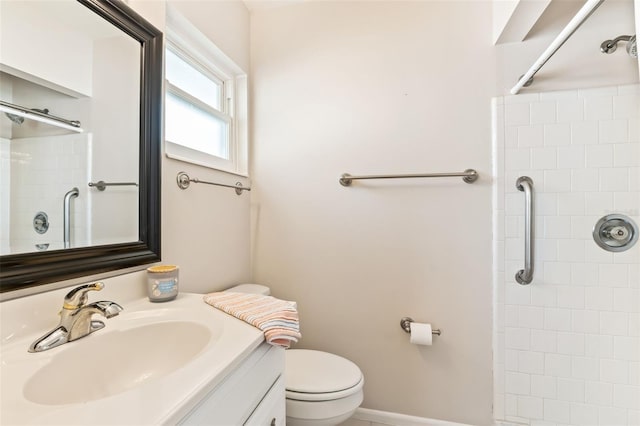 bathroom featuring vanity, toilet, and a tile shower