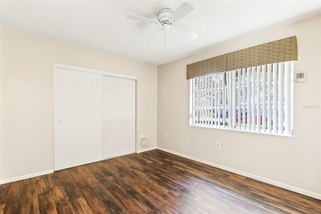 unfurnished bedroom featuring ceiling fan, dark hardwood / wood-style floors, and a closet