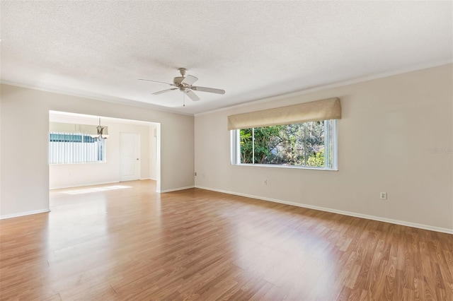 unfurnished room featuring ornamental molding, ceiling fan with notable chandelier, a textured ceiling, and light wood-type flooring