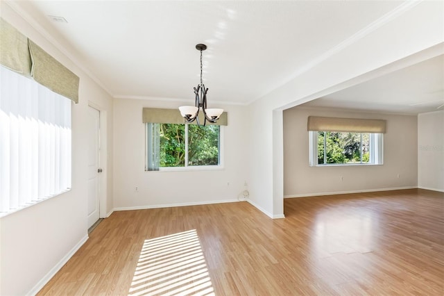 empty room featuring crown molding, a healthy amount of sunlight, and light hardwood / wood-style flooring