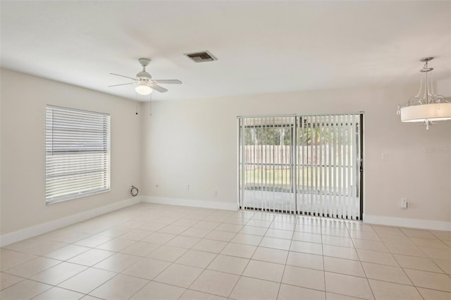 tiled empty room with ceiling fan and a healthy amount of sunlight