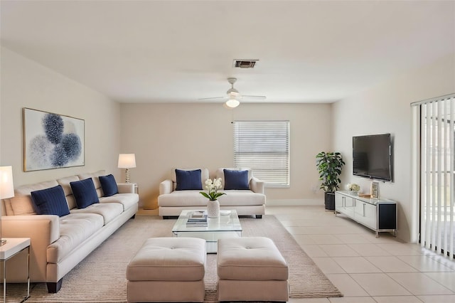 tiled living room with plenty of natural light and ceiling fan