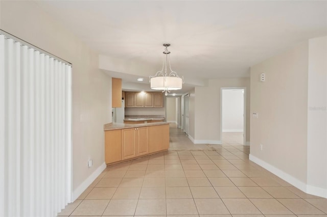 kitchen with pendant lighting, light brown cabinetry, a chandelier, and light tile patterned floors