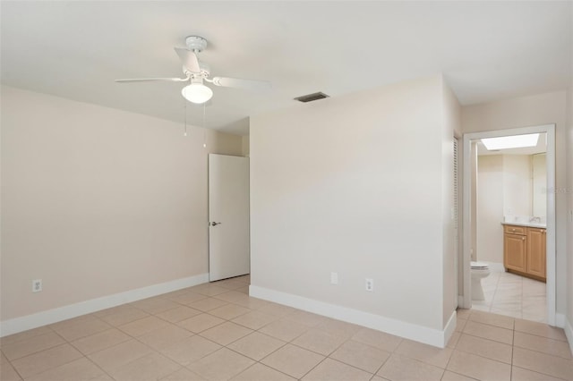 spare room featuring ceiling fan and light tile patterned floors