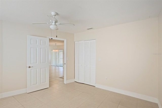 unfurnished bedroom featuring ceiling fan and a closet