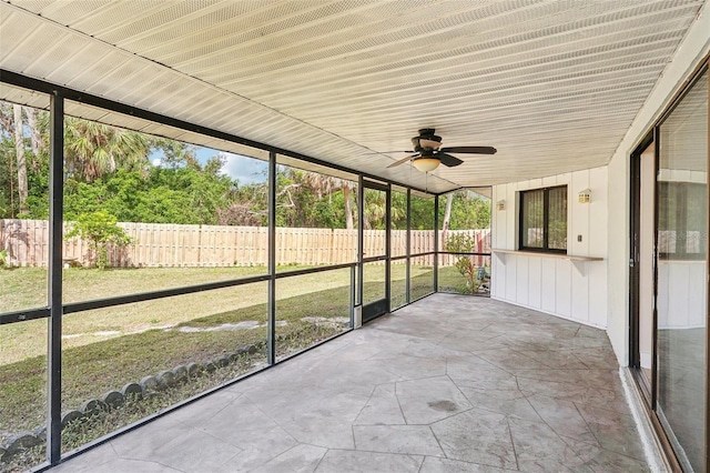 unfurnished sunroom with ceiling fan