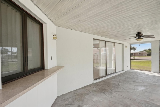 unfurnished sunroom featuring ceiling fan