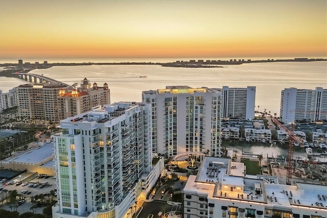 aerial view at dusk featuring a water view