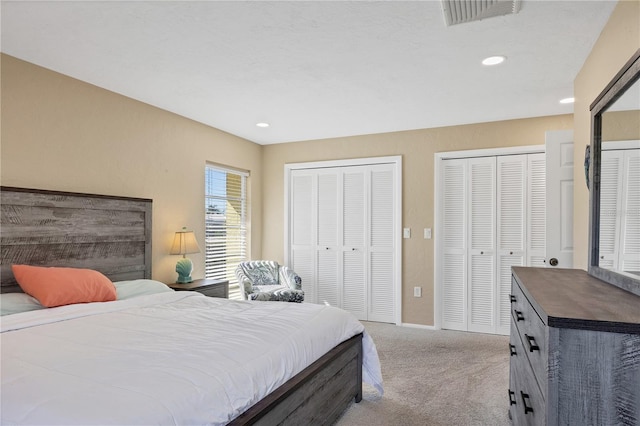 carpeted bedroom featuring two closets