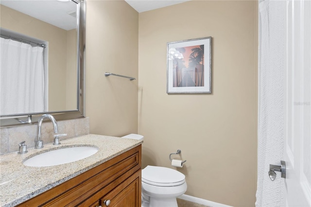 bathroom featuring vanity, backsplash, and toilet