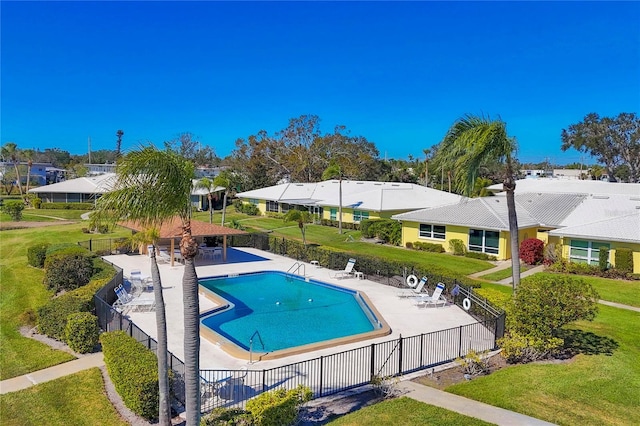 view of pool with a patio and a lawn