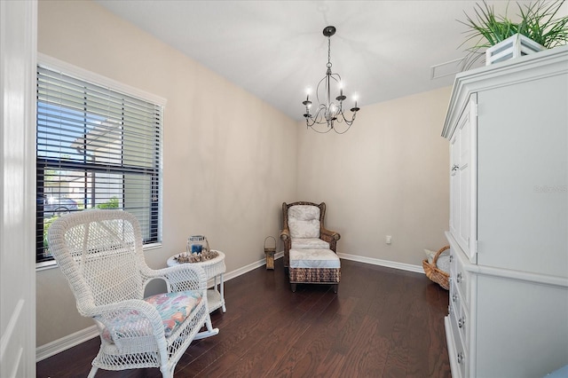 living area featuring dark hardwood / wood-style floors and a chandelier