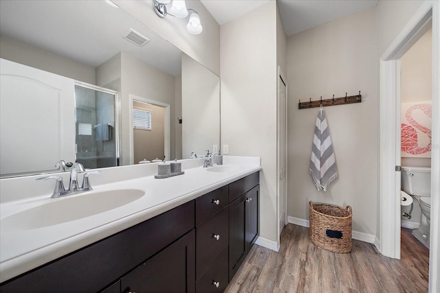 bathroom with vanity, hardwood / wood-style floors, toilet, and walk in shower