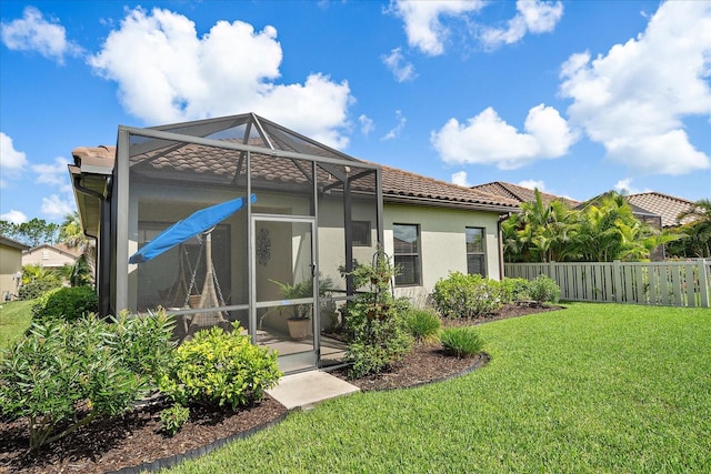 back of property with a yard and a lanai