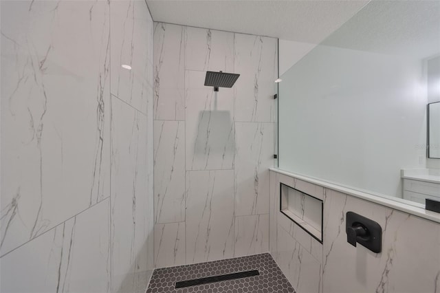 bathroom featuring a textured ceiling and a tile shower