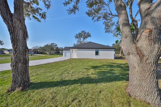 view of side of home featuring a garage and a yard