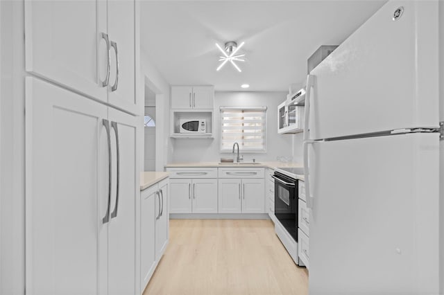 kitchen with white cabinetry, sink, white appliances, and light wood-type flooring