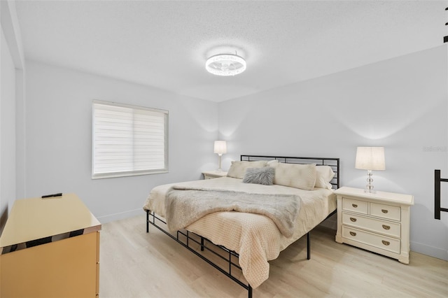 bedroom featuring a textured ceiling and light wood-type flooring