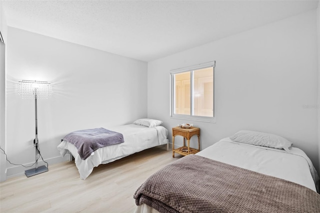 bedroom with light hardwood / wood-style flooring and a textured ceiling