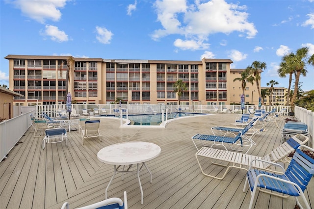 wooden deck featuring a community pool and a patio area