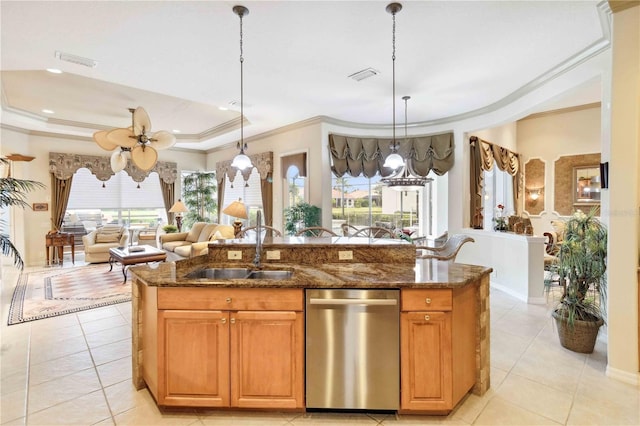 kitchen featuring pendant lighting, dishwasher, sink, dark stone countertops, and a raised ceiling