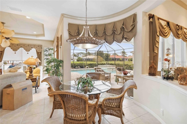 dining area featuring crown molding, light tile patterned floors, ceiling fan, and a tray ceiling