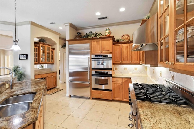 kitchen featuring sink, light stone counters, ventilation hood, appliances with stainless steel finishes, and pendant lighting