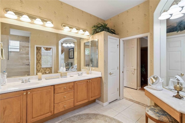 bathroom with tile patterned flooring, vanity, and a shower