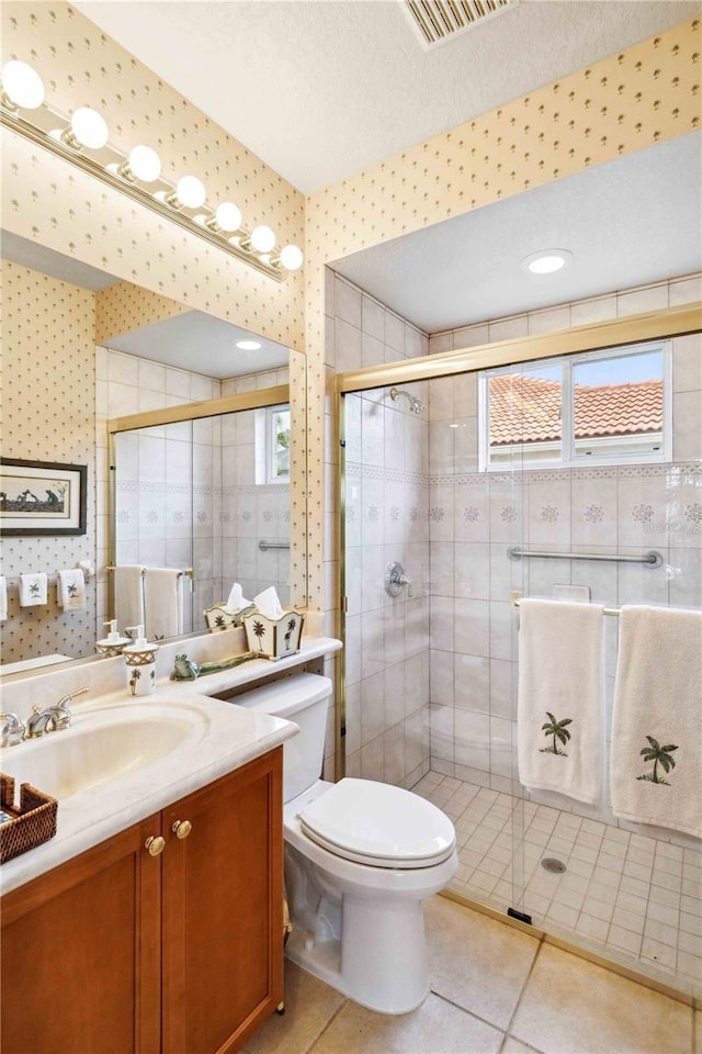 bathroom with vanity, tile patterned floors, toilet, and walk in shower