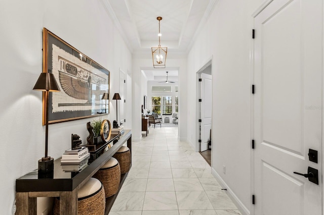 corridor with a raised ceiling and ornamental molding