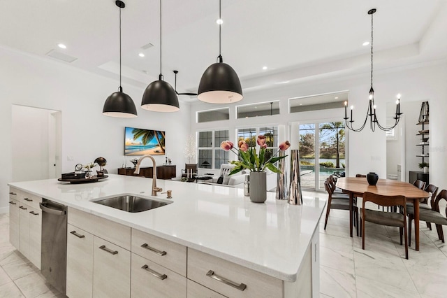 kitchen with stainless steel dishwasher, a large island, decorative light fixtures, and sink