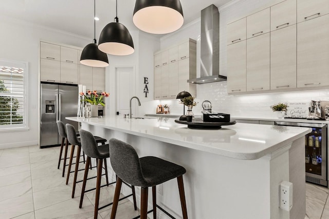 kitchen featuring hanging light fixtures, wall chimney exhaust hood, a large island with sink, and stainless steel refrigerator with ice dispenser