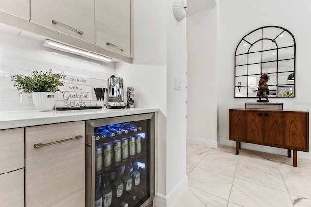 bar with tasteful backsplash, beverage cooler, and light brown cabinets