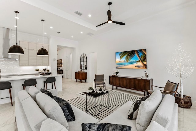 living room featuring ceiling fan and a tray ceiling