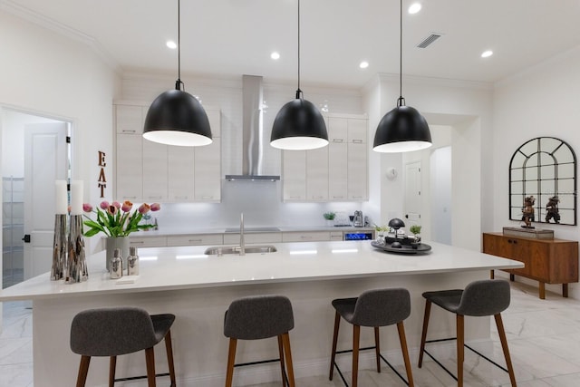 kitchen featuring white cabinetry, a spacious island, decorative light fixtures, and wall chimney exhaust hood