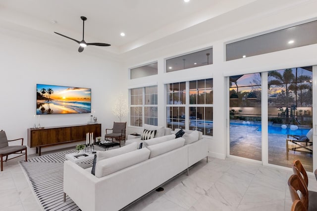 living room with ceiling fan and a high ceiling