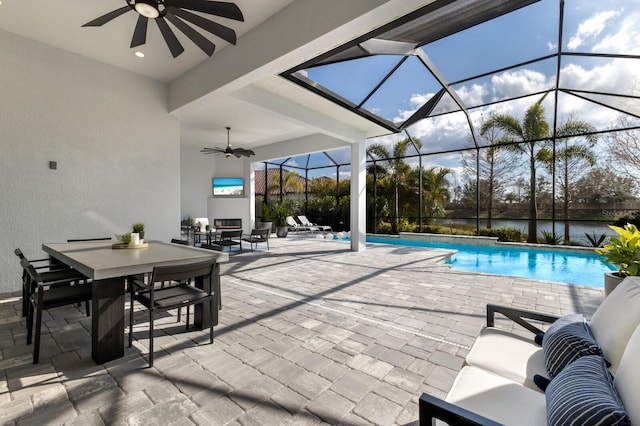 view of swimming pool featuring ceiling fan, outdoor lounge area, a patio area, and glass enclosure