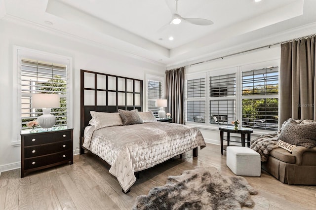 bedroom with hardwood / wood-style flooring, ornamental molding, and a raised ceiling