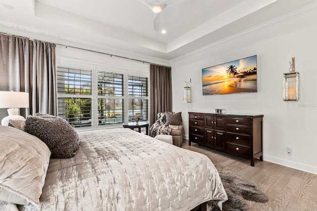 bedroom featuring light hardwood / wood-style flooring and a raised ceiling