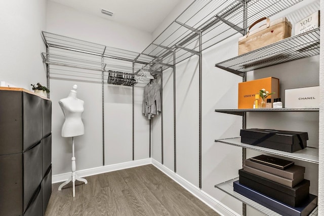 walk in closet with hardwood / wood-style floors