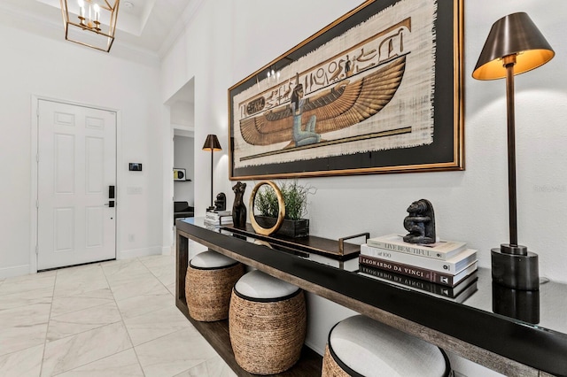 foyer featuring ornamental molding and a chandelier