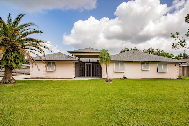 back of property featuring a yard and a sunroom