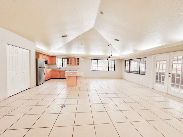 kitchen with french doors, sink, a textured ceiling, light tile patterned floors, and appliances with stainless steel finishes