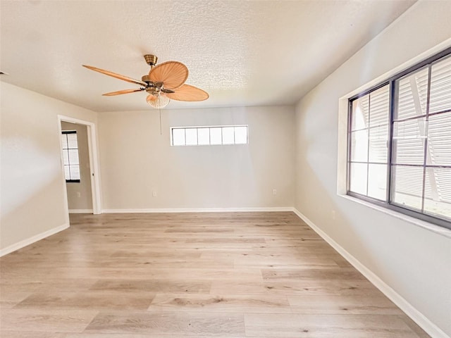 empty room featuring a textured ceiling, ceiling fan, and light wood-type flooring